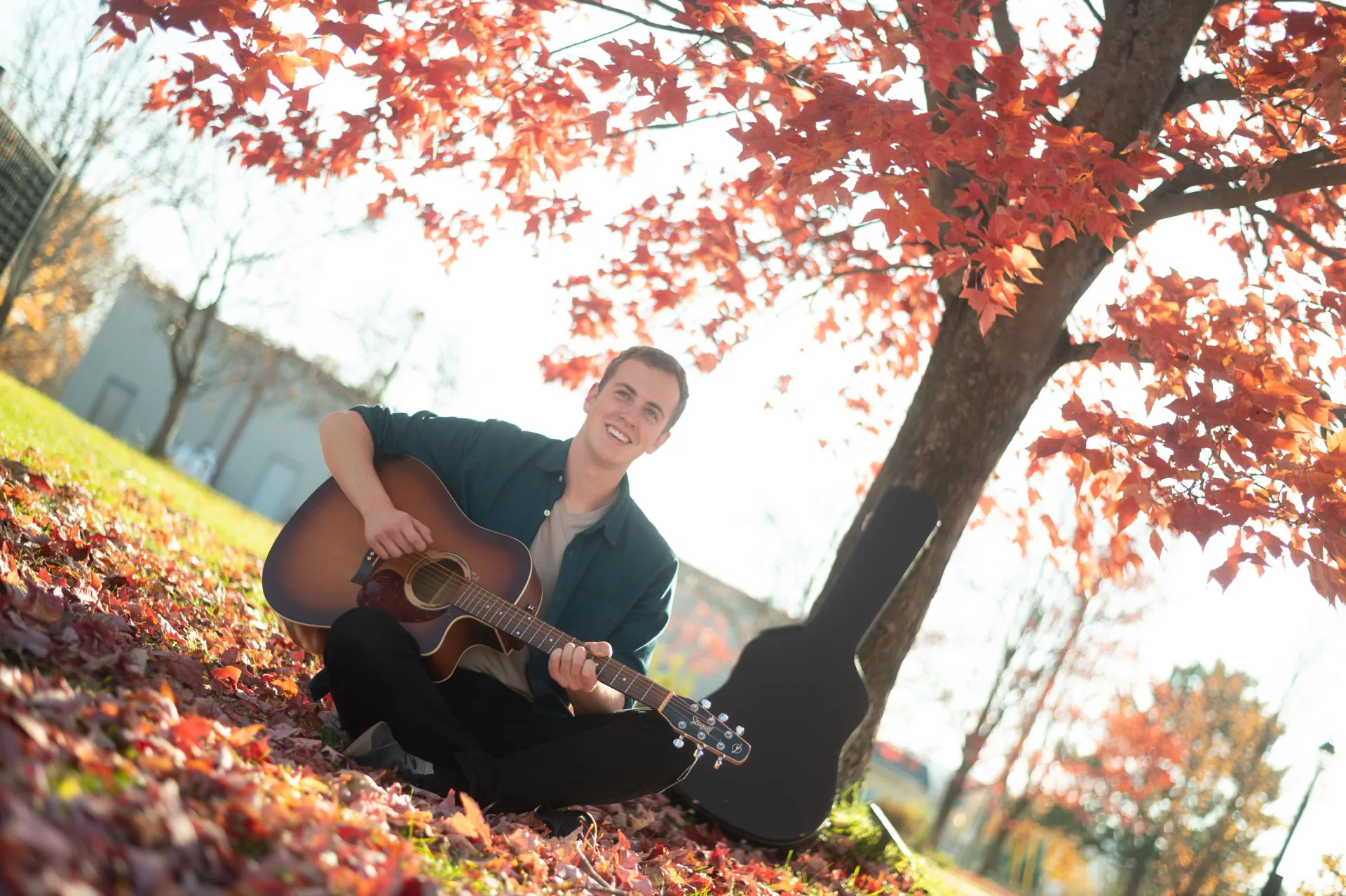 Musician playing acoustic guitar at a warm, intimate venue